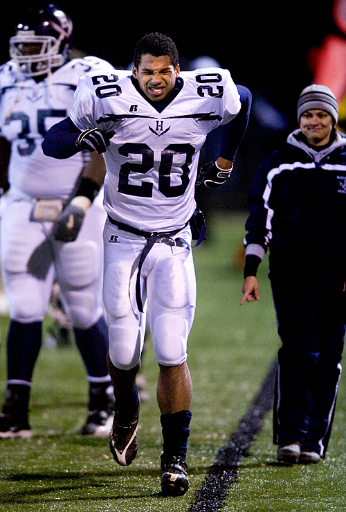 Harrisonburg tailback MIchael Holmes limps along the sidelines after having his right ankle taped following an  injury in the first quarter of the regional final in Amherst Friday night.