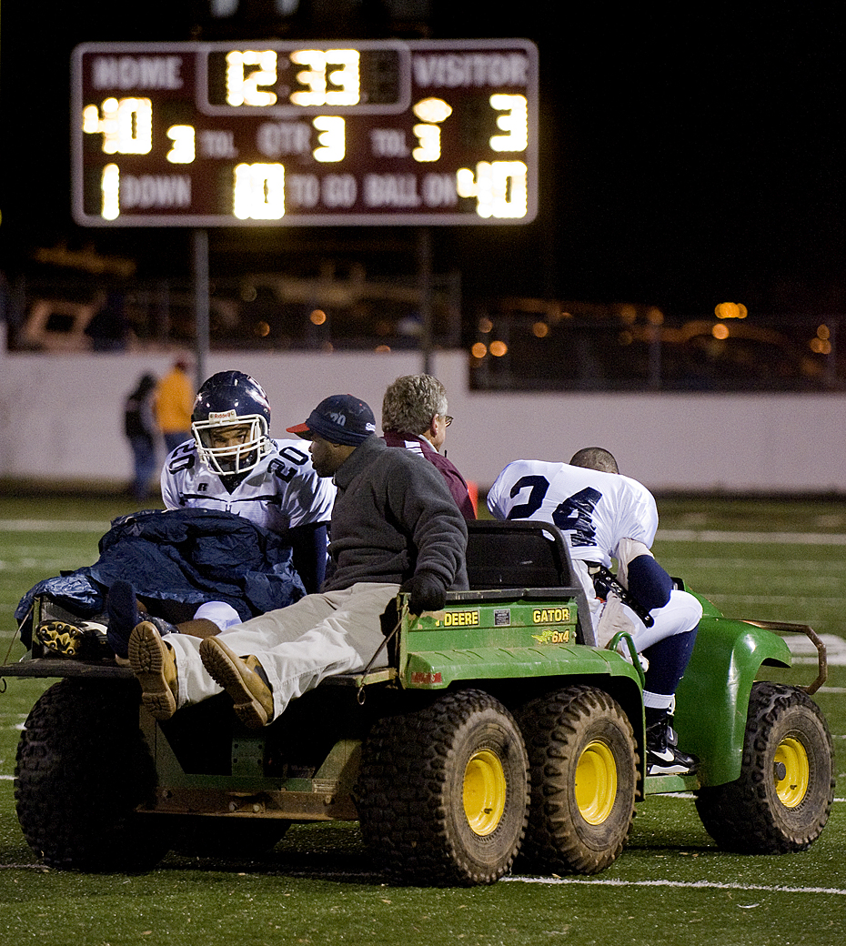Harrisonburg's Michael Holmes and Xaviel Esela are transported from the field at halftime.