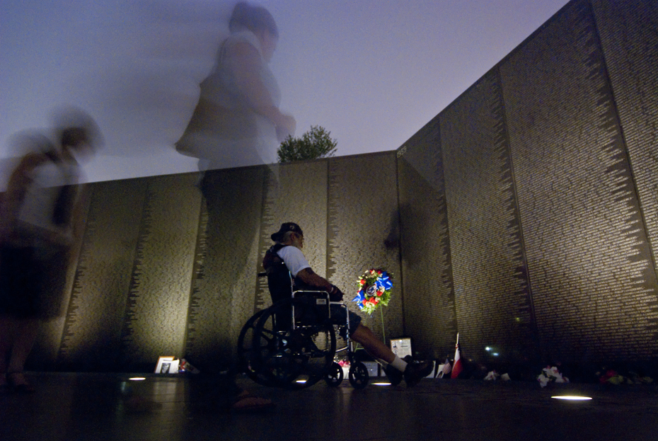 A wheelchair bound veteran visits the Vietnam Veteran's Memorial, also known as "The Wall."