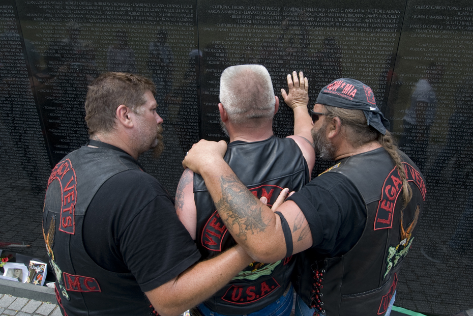 Two veterans of the Vietnam war comfort a comrade during his visit to the Vietnam Veteran's Memorial in Washington, D.C.