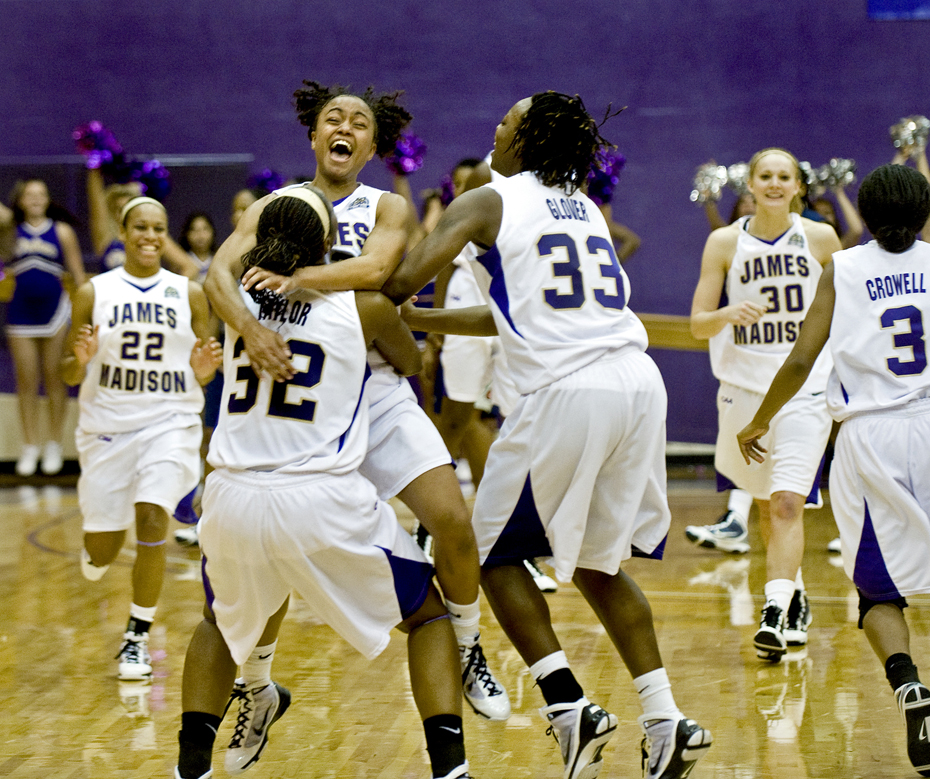James Madison University's Dawn Evans jumps into the arms of her teammate Jalissa Taylor as they celebrate their upset win over Georgetown at the JMU Convocation Center in Harrisonburg on Wednesday. The Dukes came from 16 points down at one point to win 79-76.