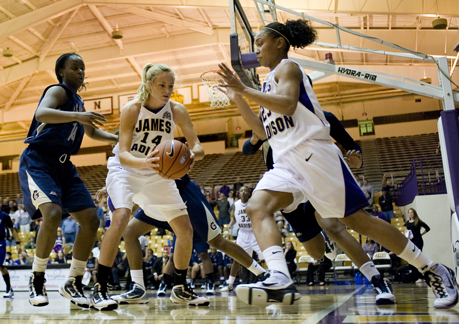 James Madison's Dawn Evans comes to the aid of teammate Sara Williams during first-half action at the JMU Convocation Center in Harrisonburg on Wednesday. JMU upset the Hoyas 79-76.