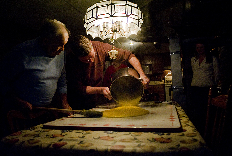 Joe and Fritz pour out the polenta onto a board on the dining table.