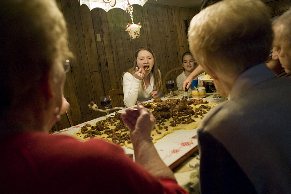 Sitting around the table having a feast. Yep, it is eaten right off the board. My wife, Jenny is taking a big bite.