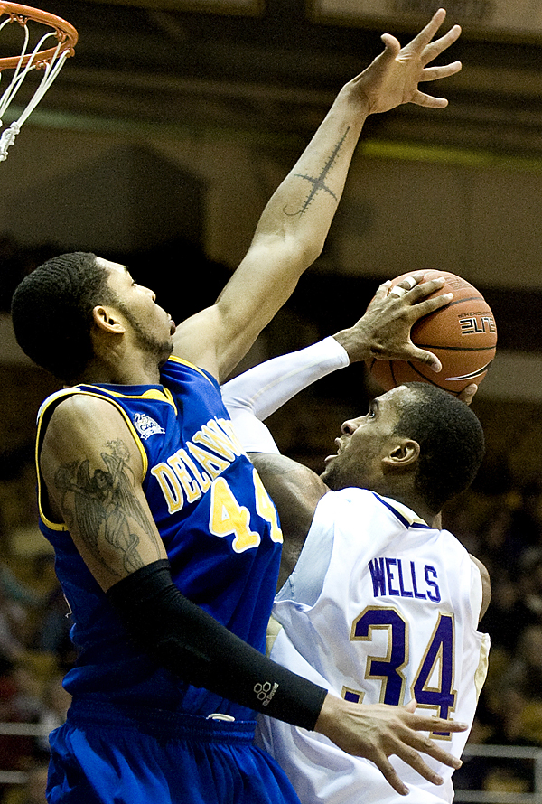 James Madison'a Julius Wells drives the lane against Delaware's Jamelle Hagins during second half action at the JMU Convo on Monday night.