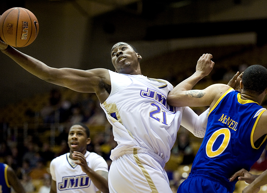James Madison's Denzel Bowles reaches for a loose ball during first-quarter action against Delaware at the JMU Convo on Monday night. Bowles scored 26 points in JMU's 71-65 win.