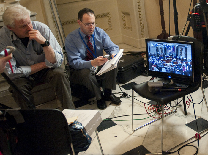 20100321779 A television crew watches the historic vote on a monitor outside of the House Chambers.