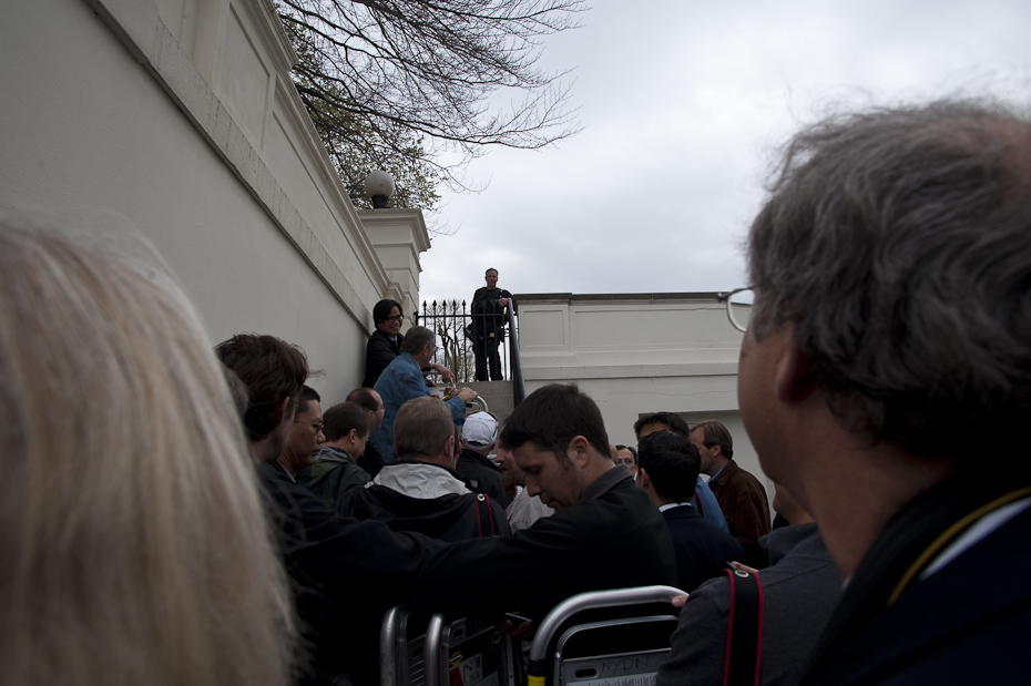 The press waits for the OK to enter the White House's East Room for setup.